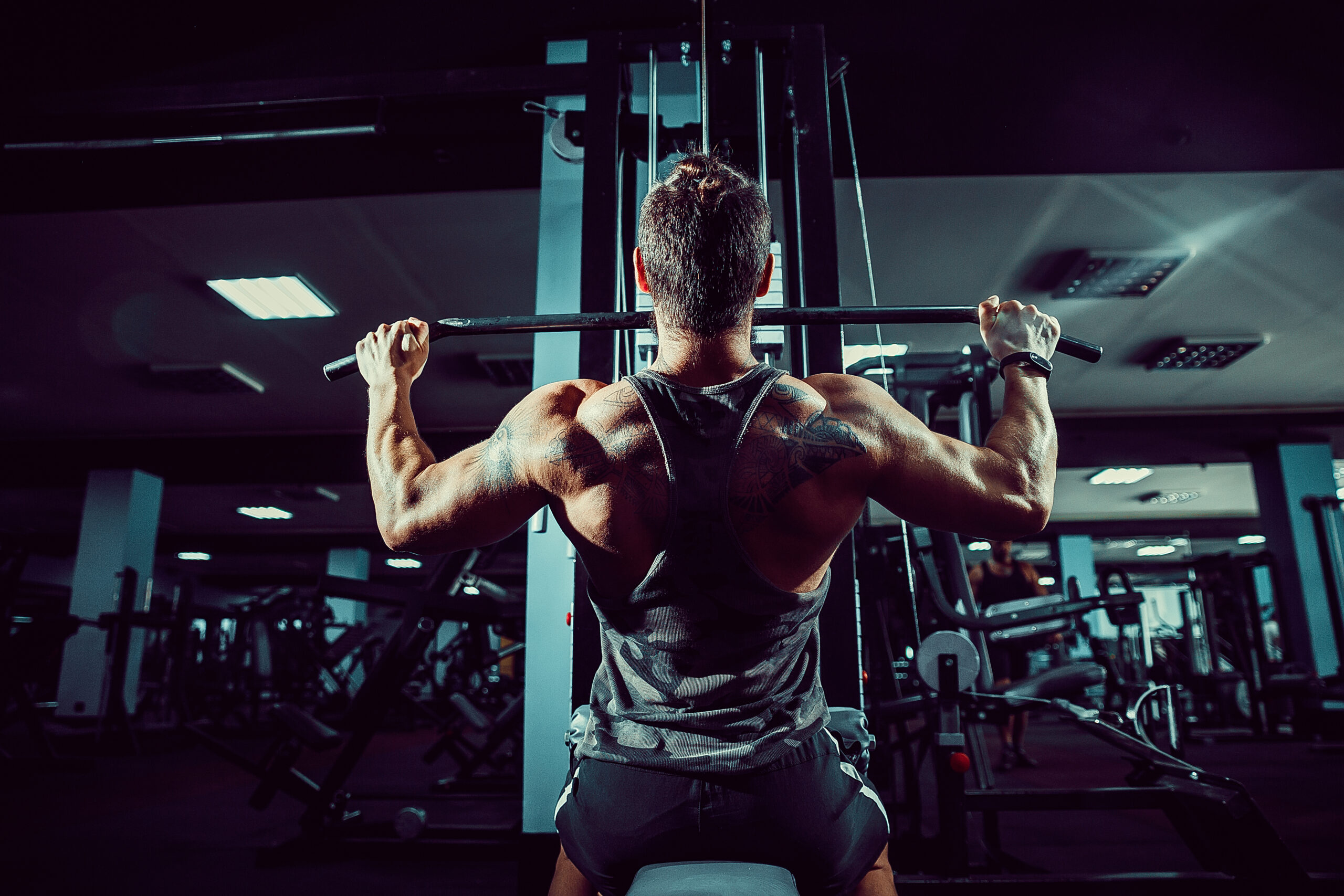 Strong Bodybuilder Doing Heavy Weight Exercise For Back On Machine