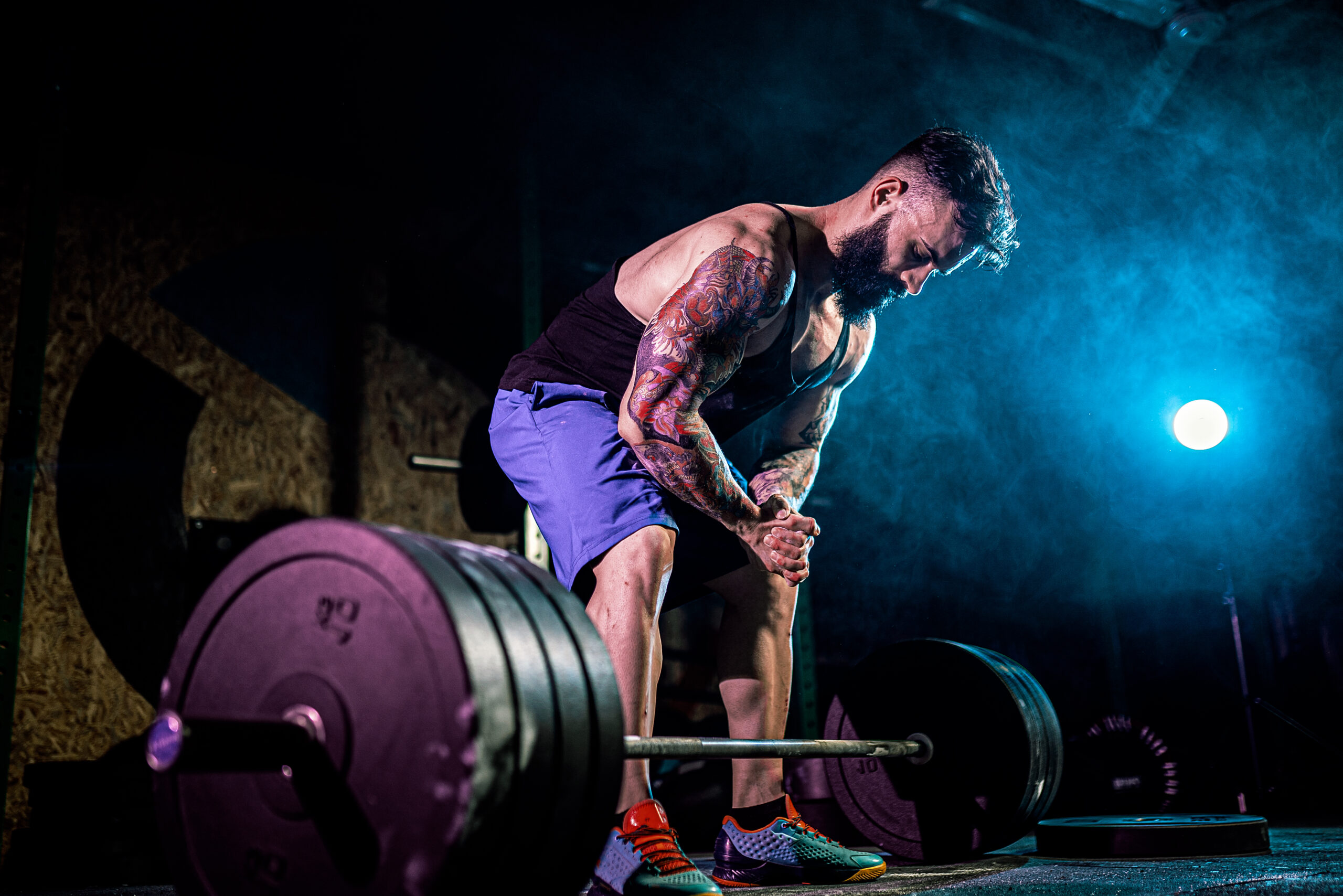 Muscular fitness man preparing to deadlift a barbell in modern fitness center. Functional training. Snatch exercise